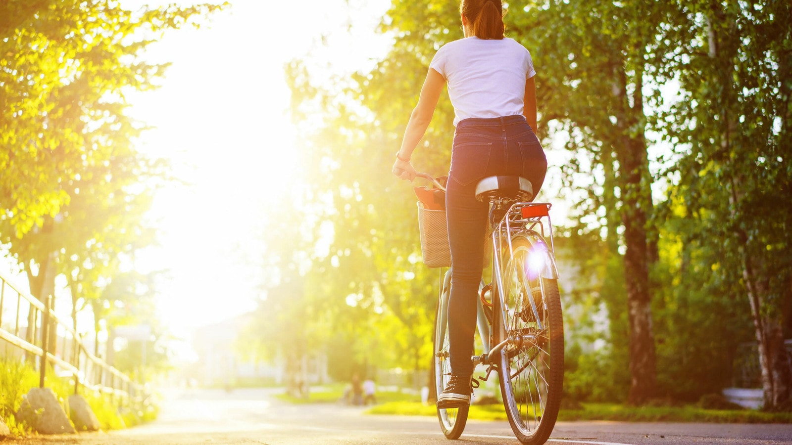 Eine Frau fährt Fahrrad im Sonnenschein.
