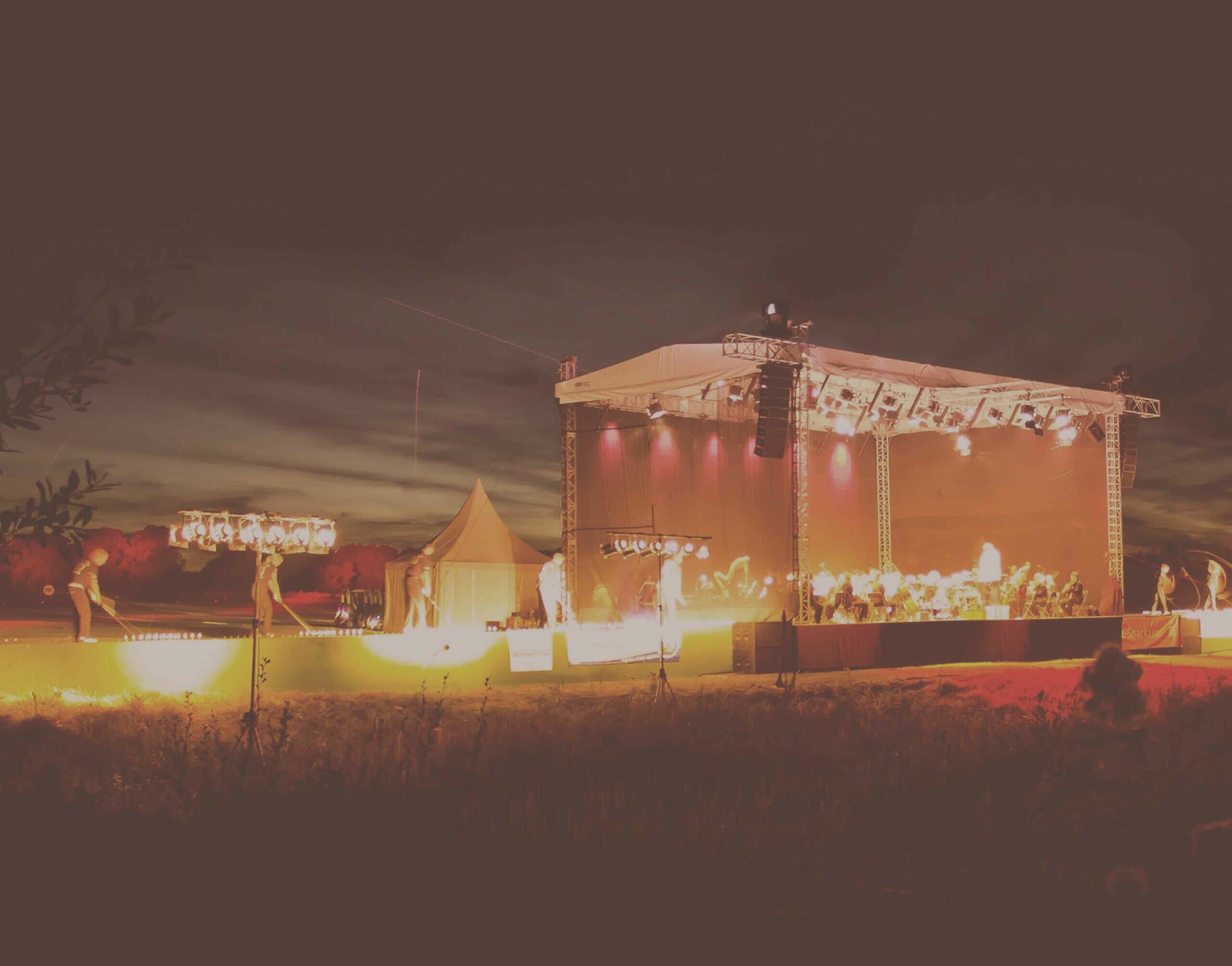 Eine Bühne auf der ein Event stattfindet bei Nacht.