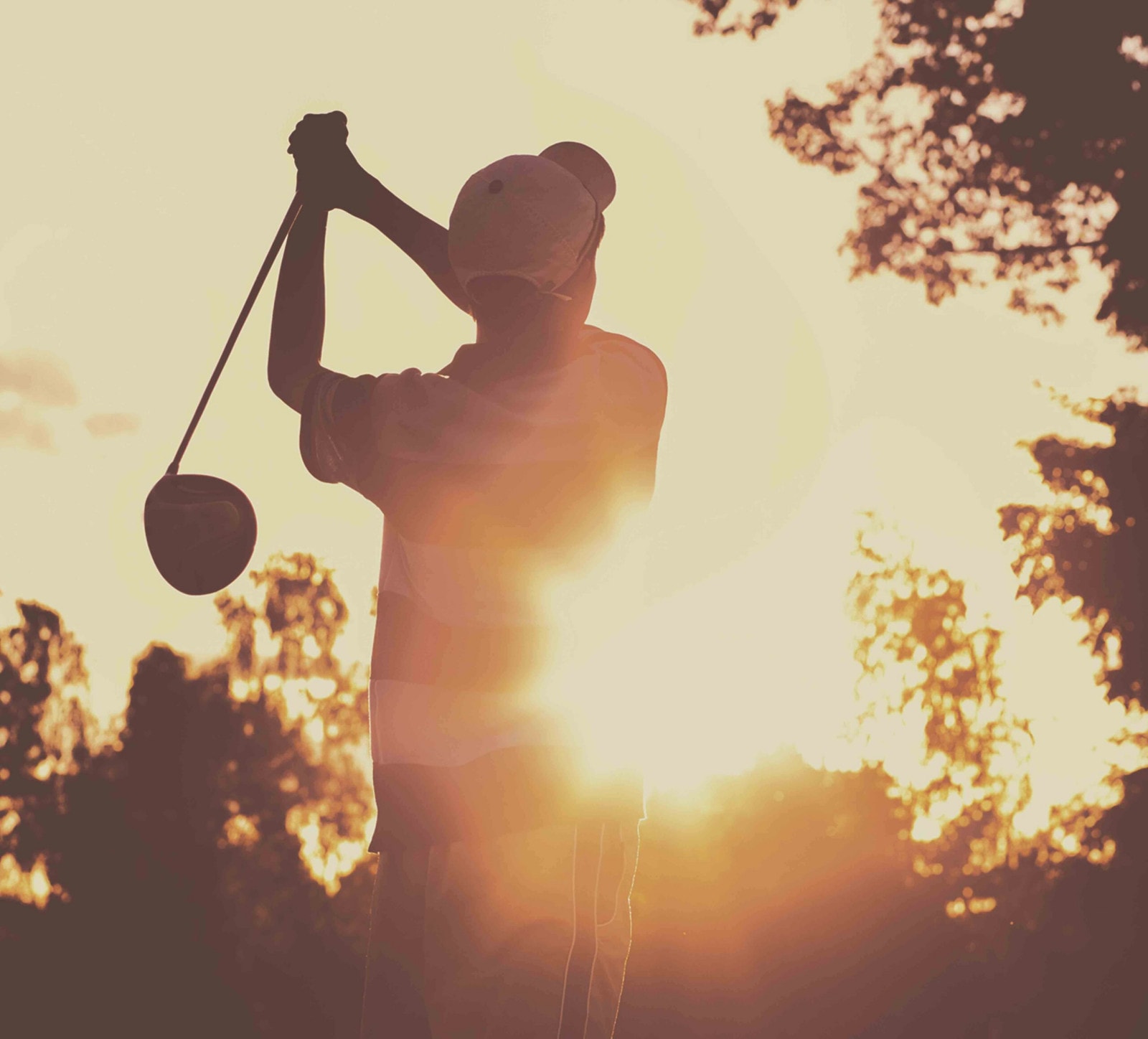 Ein Golfabschlag im Sonnenuntergang.